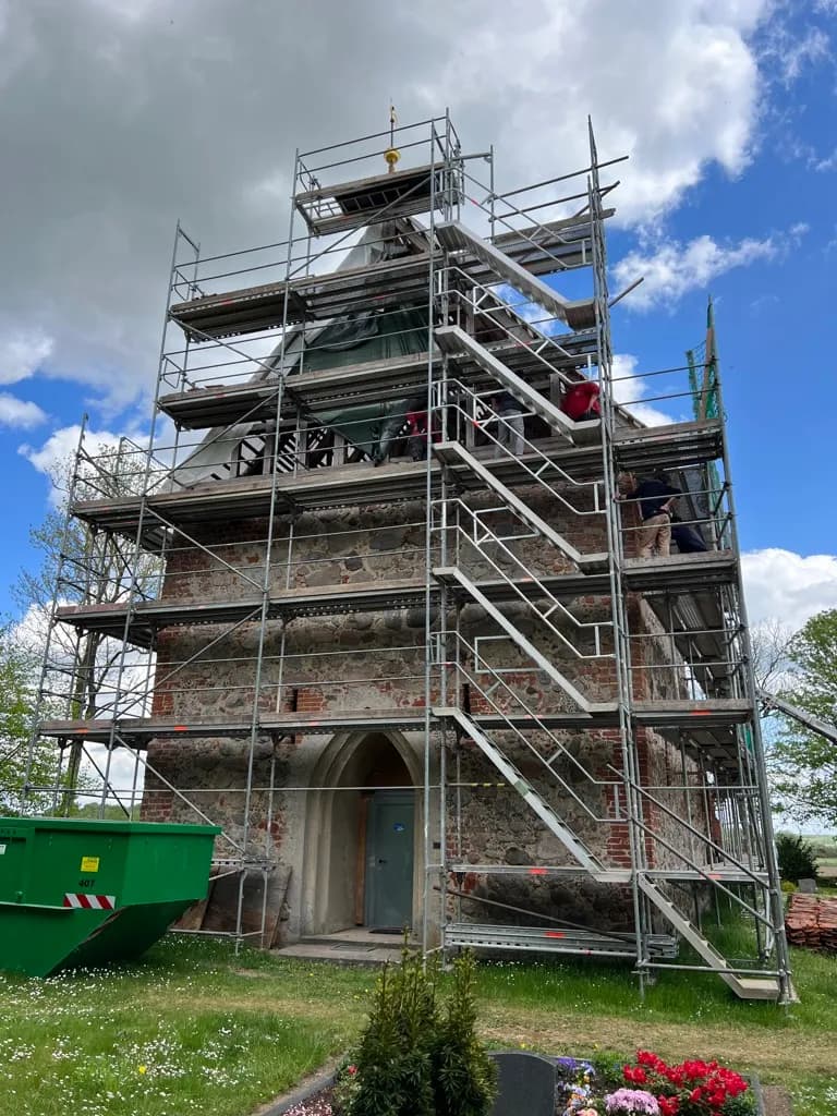 Komplett eingerüsteter Kirchturm der Feldsteinkirche Wessin als freistehendes Standgerüst mit Treppenaufstieg, SCHWAN Gerüstbau